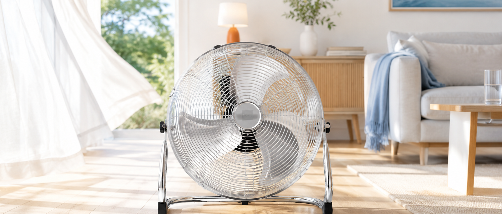Nyxi metal floor fan with chrome grill in a bright summer living room